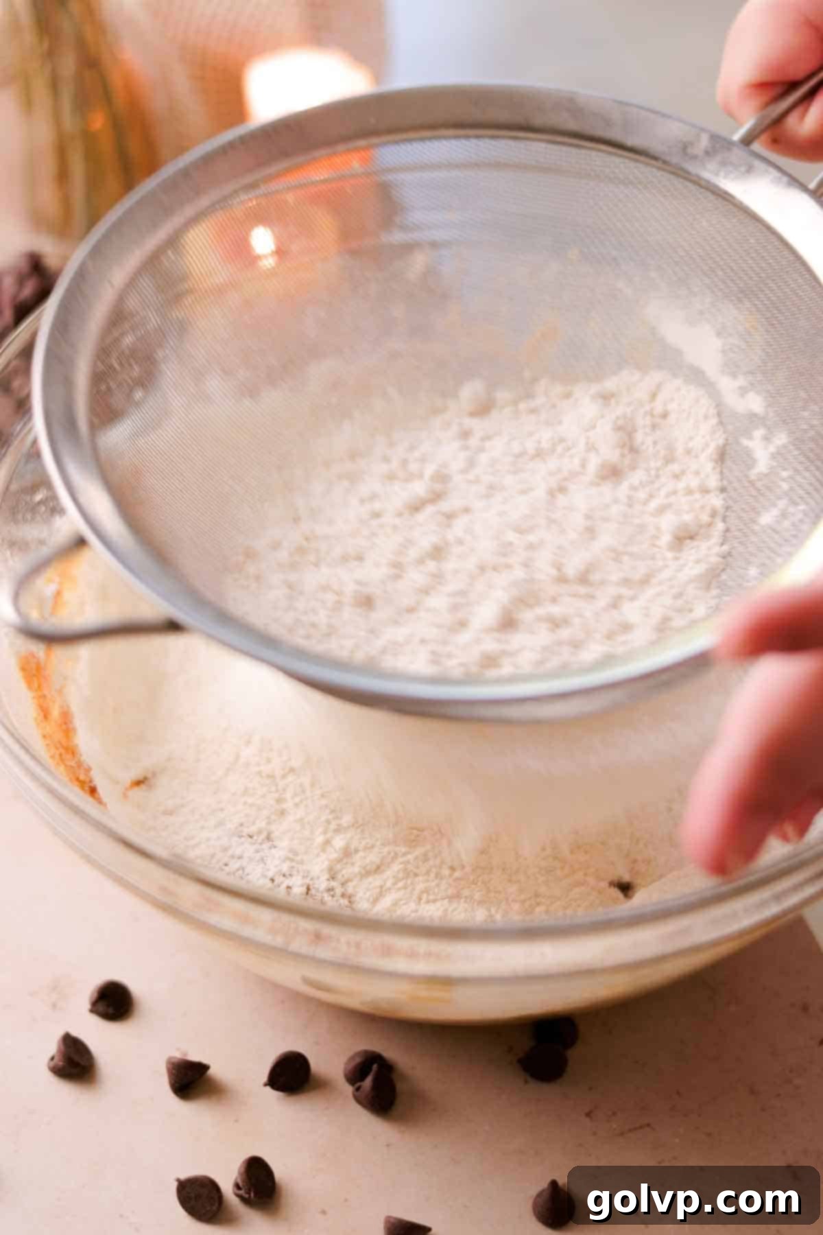 Heavenly Toffee Cookies: Our Foolproof Homemade Toffee Secret 14 sifting flour into glass bowl with metal sieve
