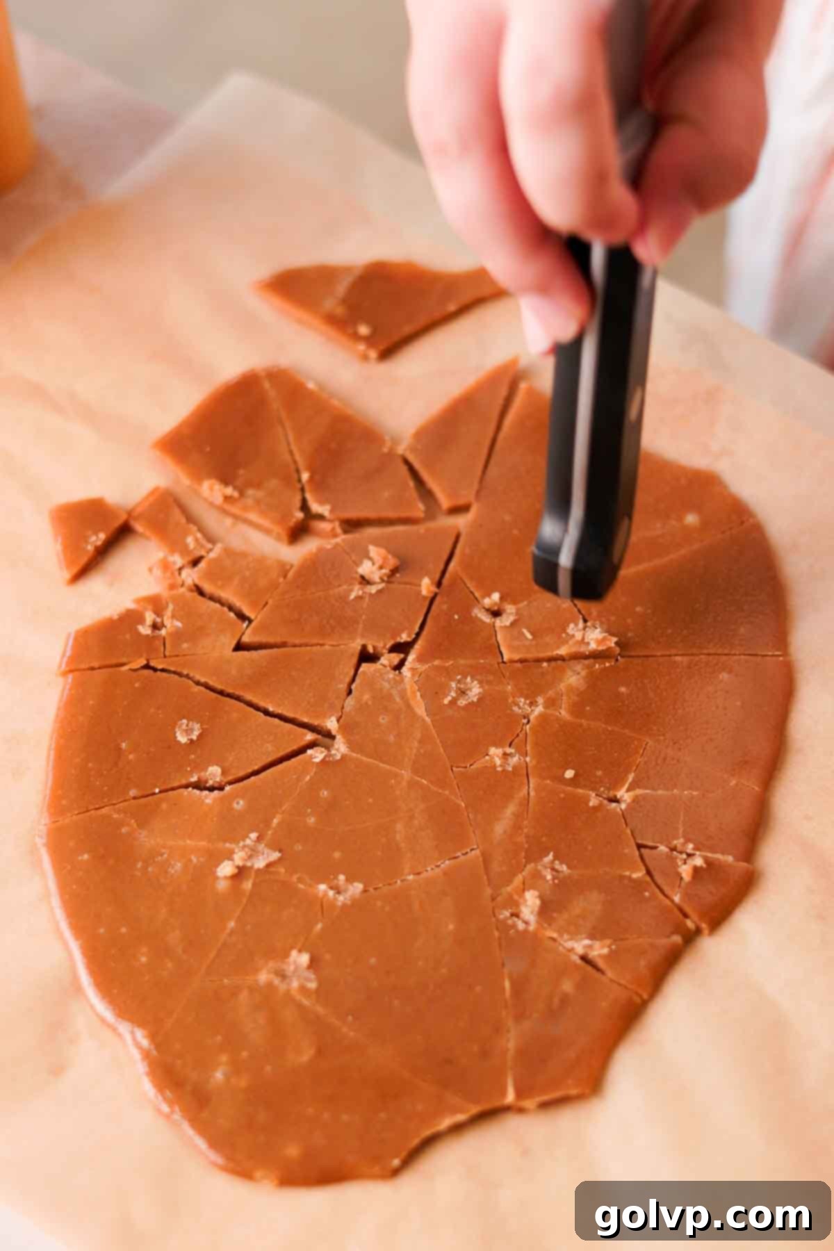 Heavenly Toffee Cookies: Our Foolproof Homemade Toffee Secret 9 cracking toffee into shards on parchment paper with knife handle