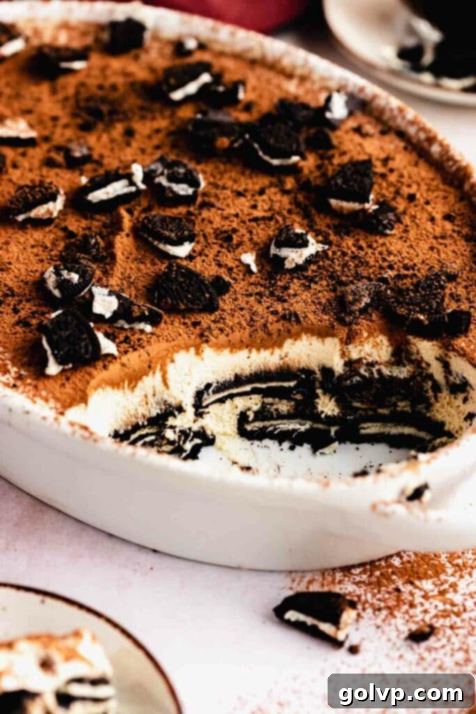 Oreo Tiramisu Delight 2 Taking a scoop out of a tray with beautifully layered Oreo Tiramisu, showcasing its rich texture and distinct layers.