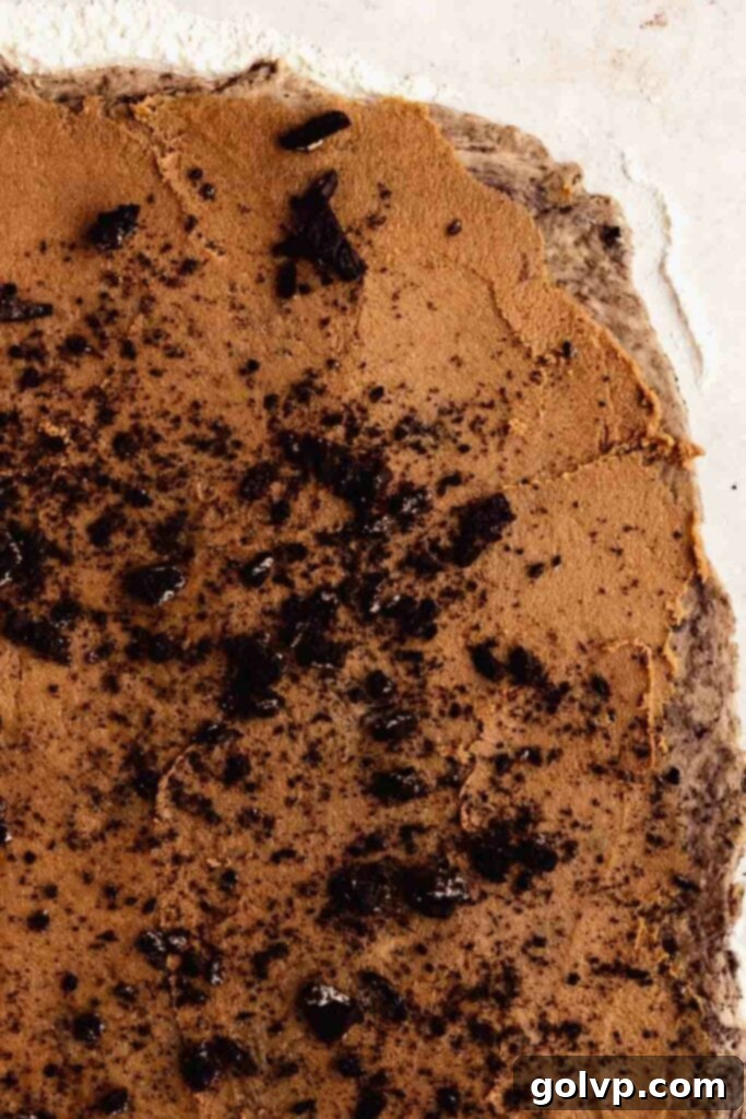 Step-by-step: Spreading the luscious cinnamon and crushed Oreo filling onto the rolled dough.