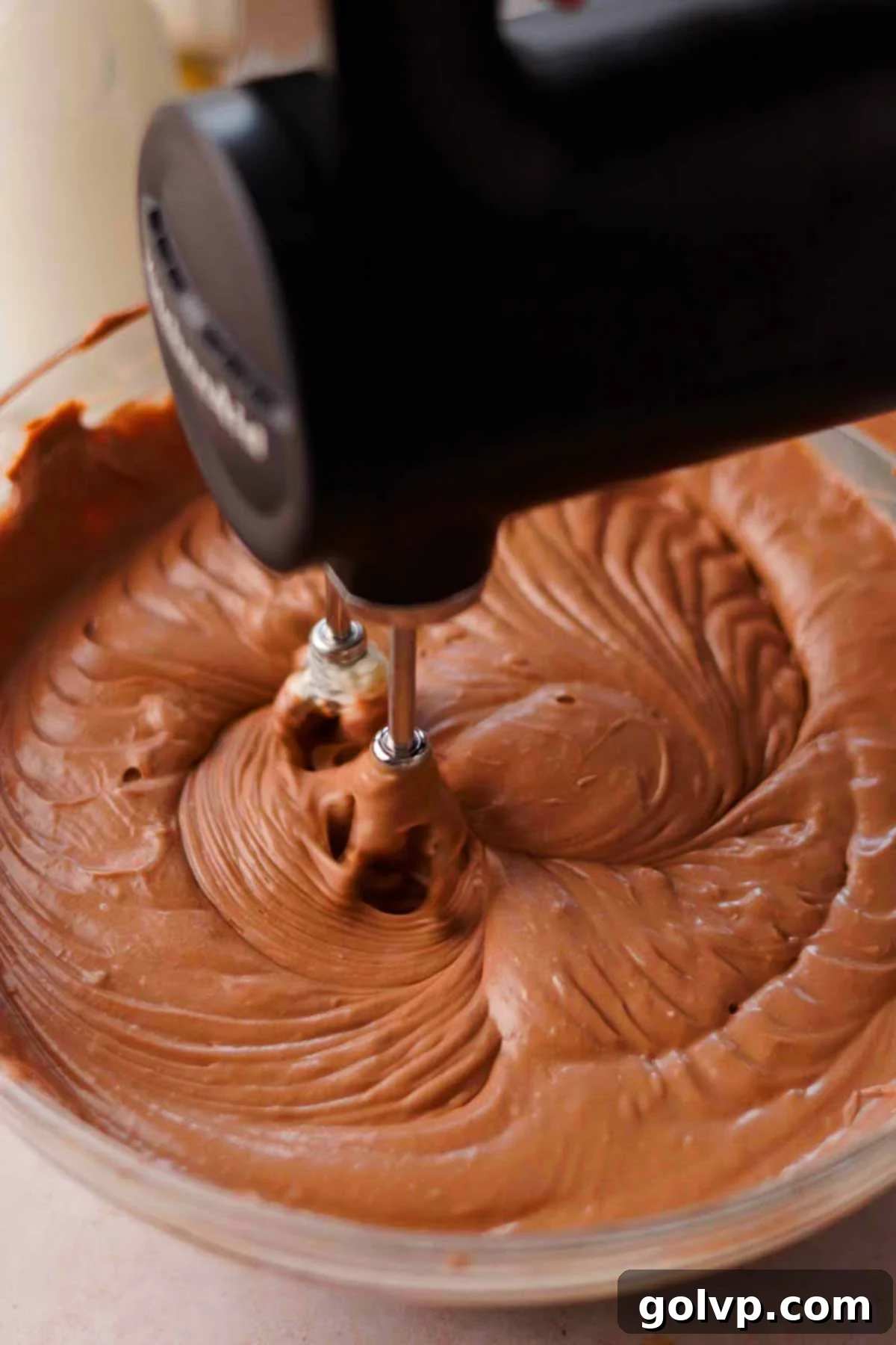 beating nutella cheesecake batter together with electric mixer