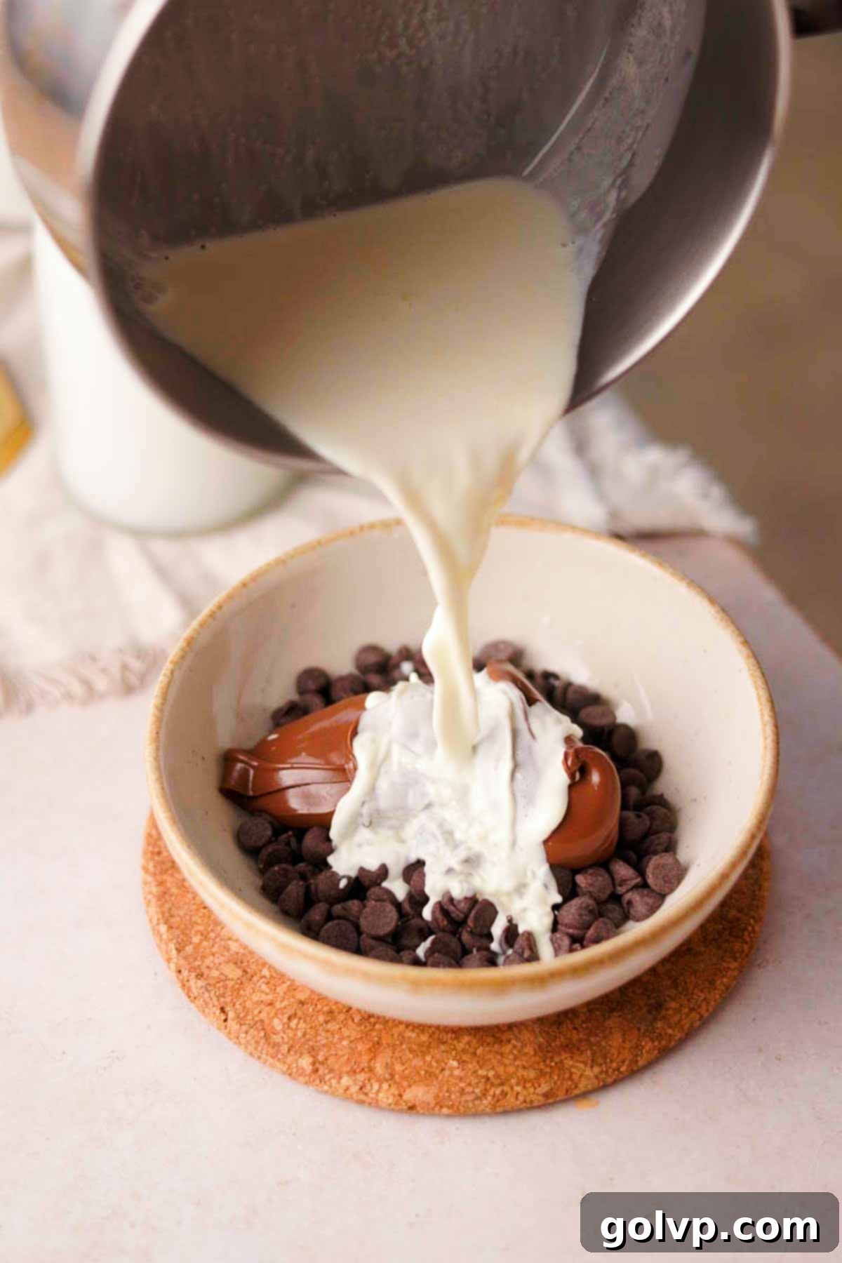 pouring hot cream over chocolate and nutella to melt