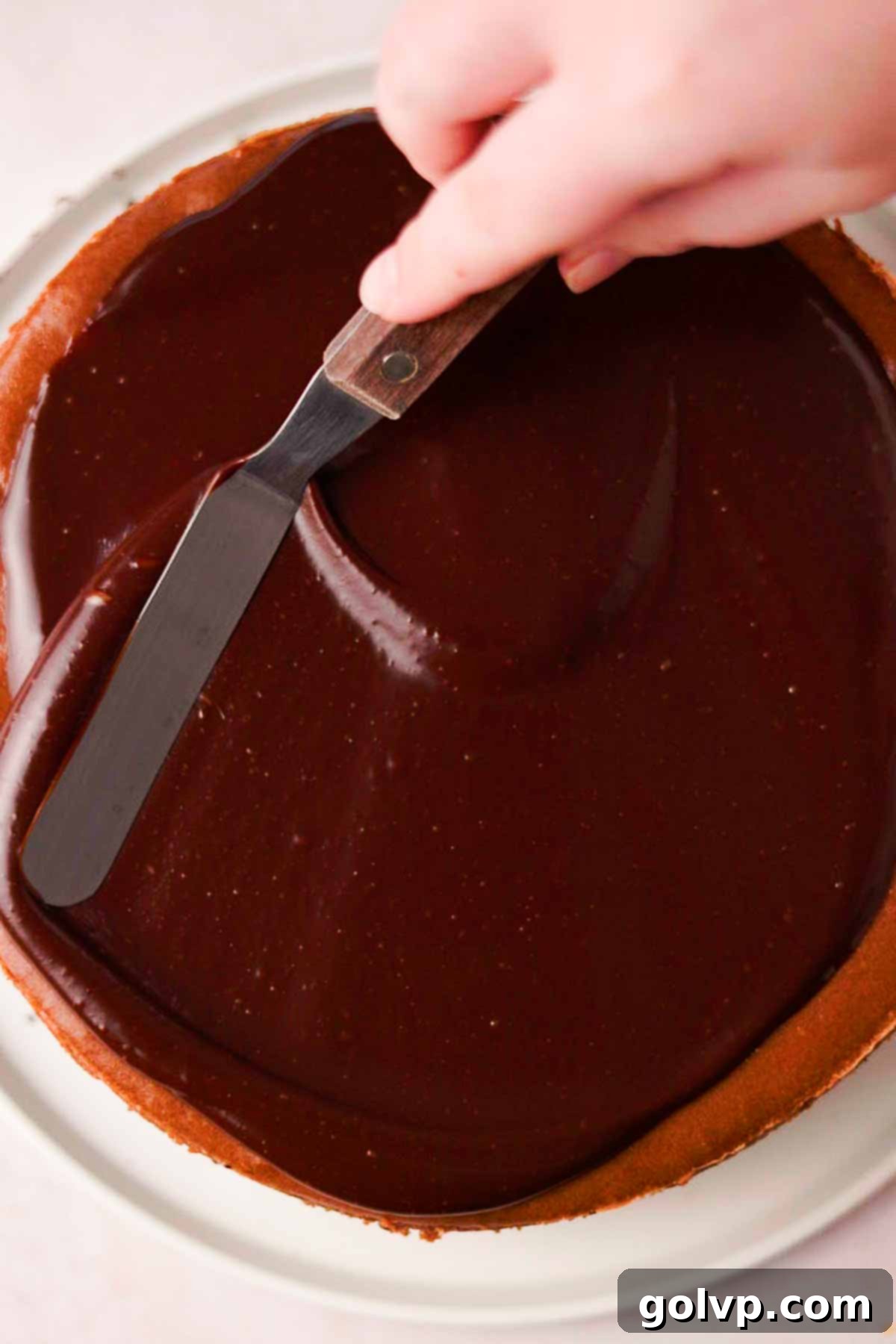 spreading nutella ganache on set cheesecake