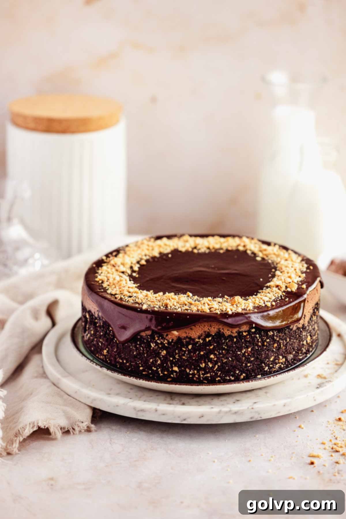 nutella cheesecake on cake plate with chopped hazelnuts