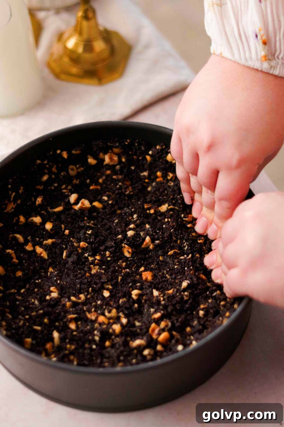 pressing chocolate hazelnut crust into baking pan