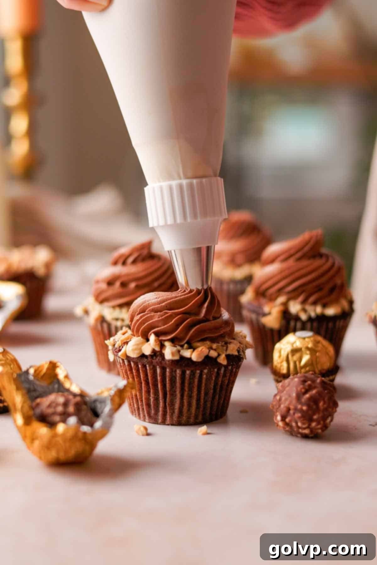 piping creamy nutella frosting on top of ferrero rocher cupcake