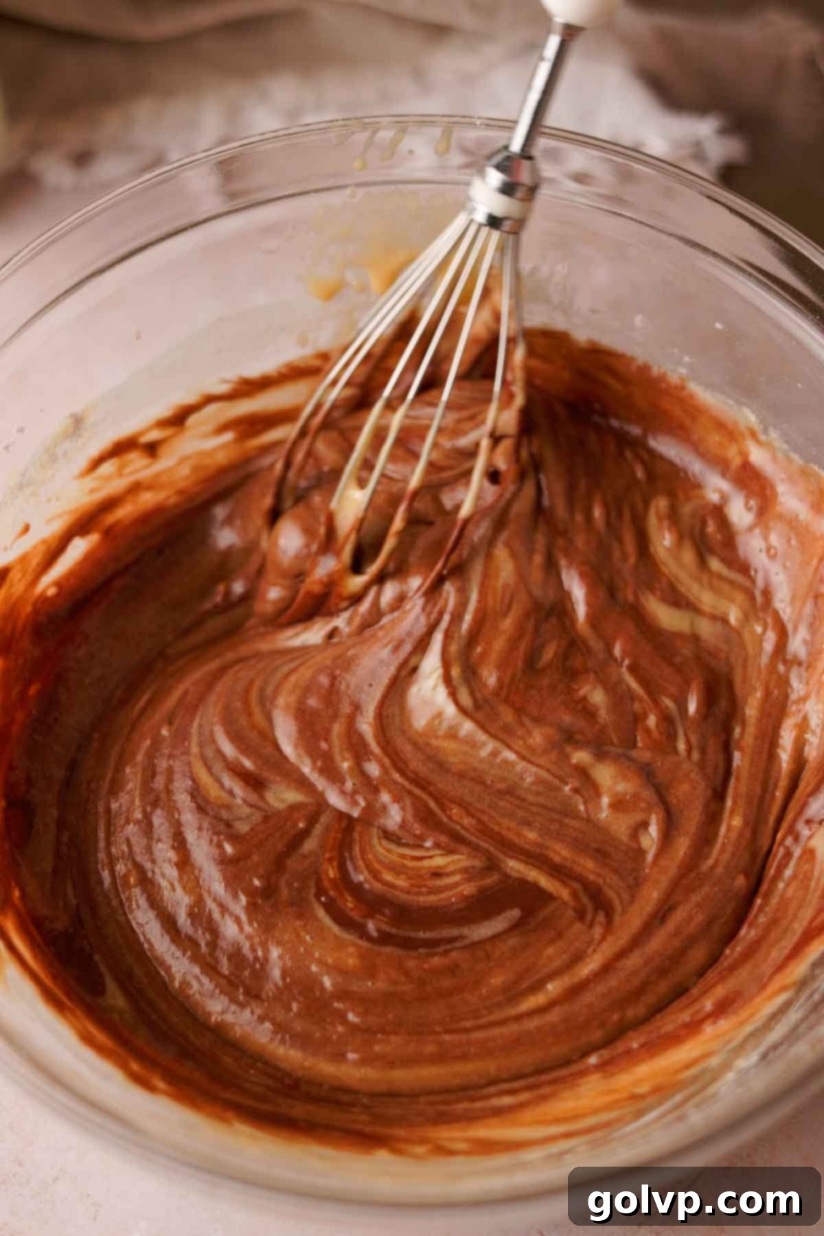 whisking chocolate cupcake batter with a whisk