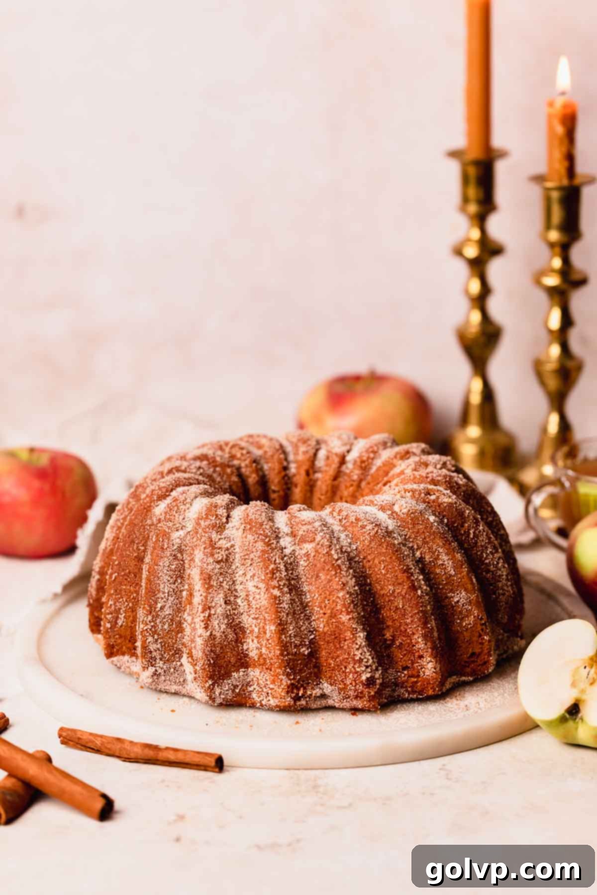 Spiced Autumn Apple Bundt 15 apple cider donut cake on serving plate with candles