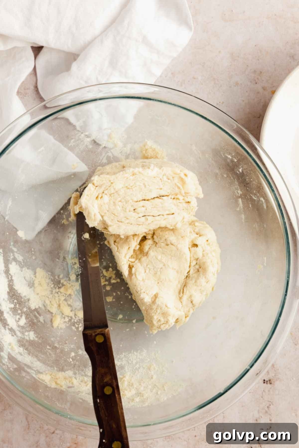 Pie dough disks being divided in half before chilling.