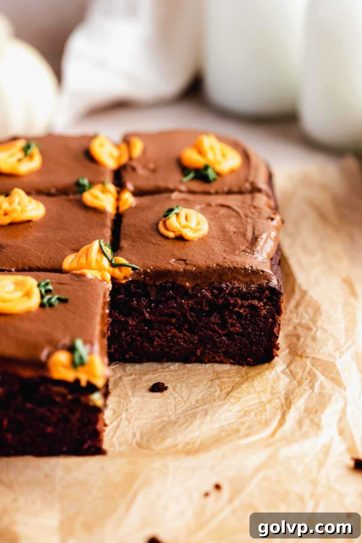 Perfectly sliced pumpkin chocolate cake revealing its moist, rich interior and topped with frosting and mini pumpkins
