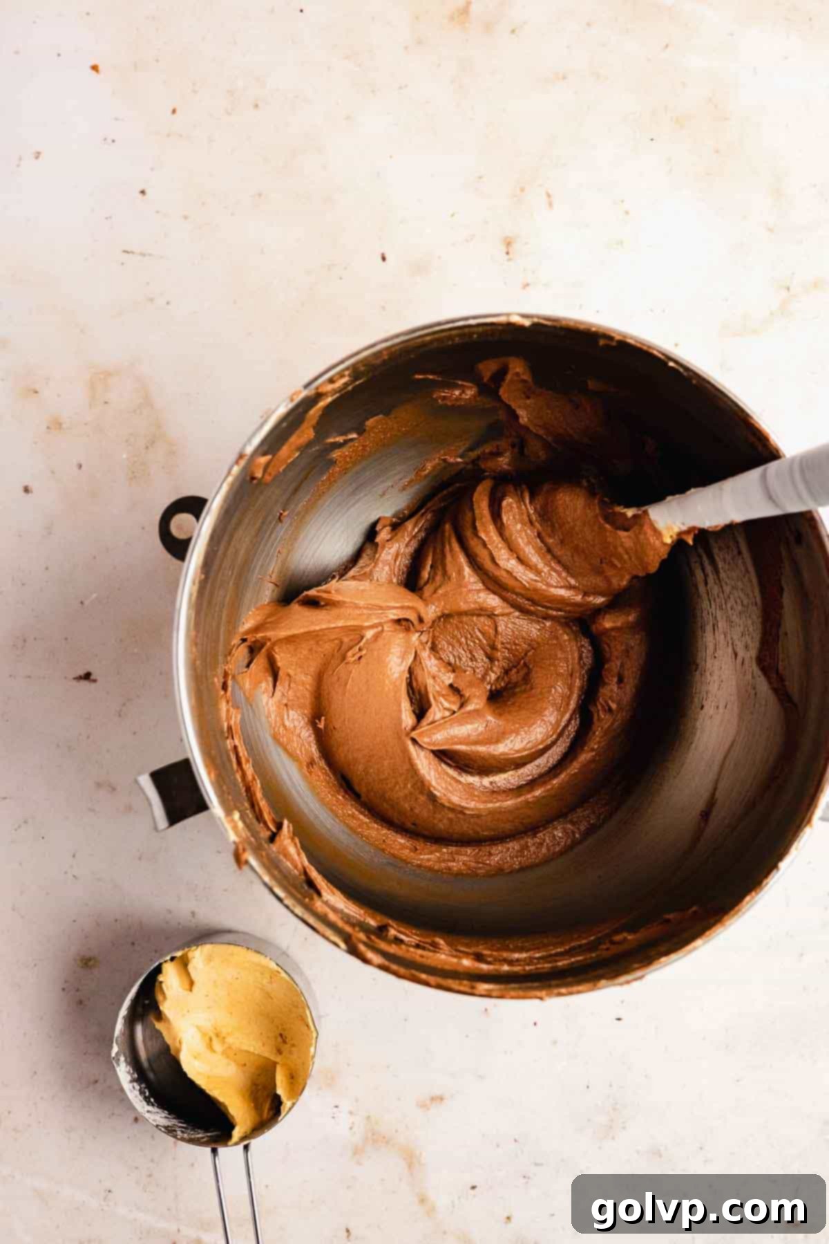 Creamy, prepared chocolate pumpkin buttercream in a stand mixer bowl, ready to be spread onto the cake