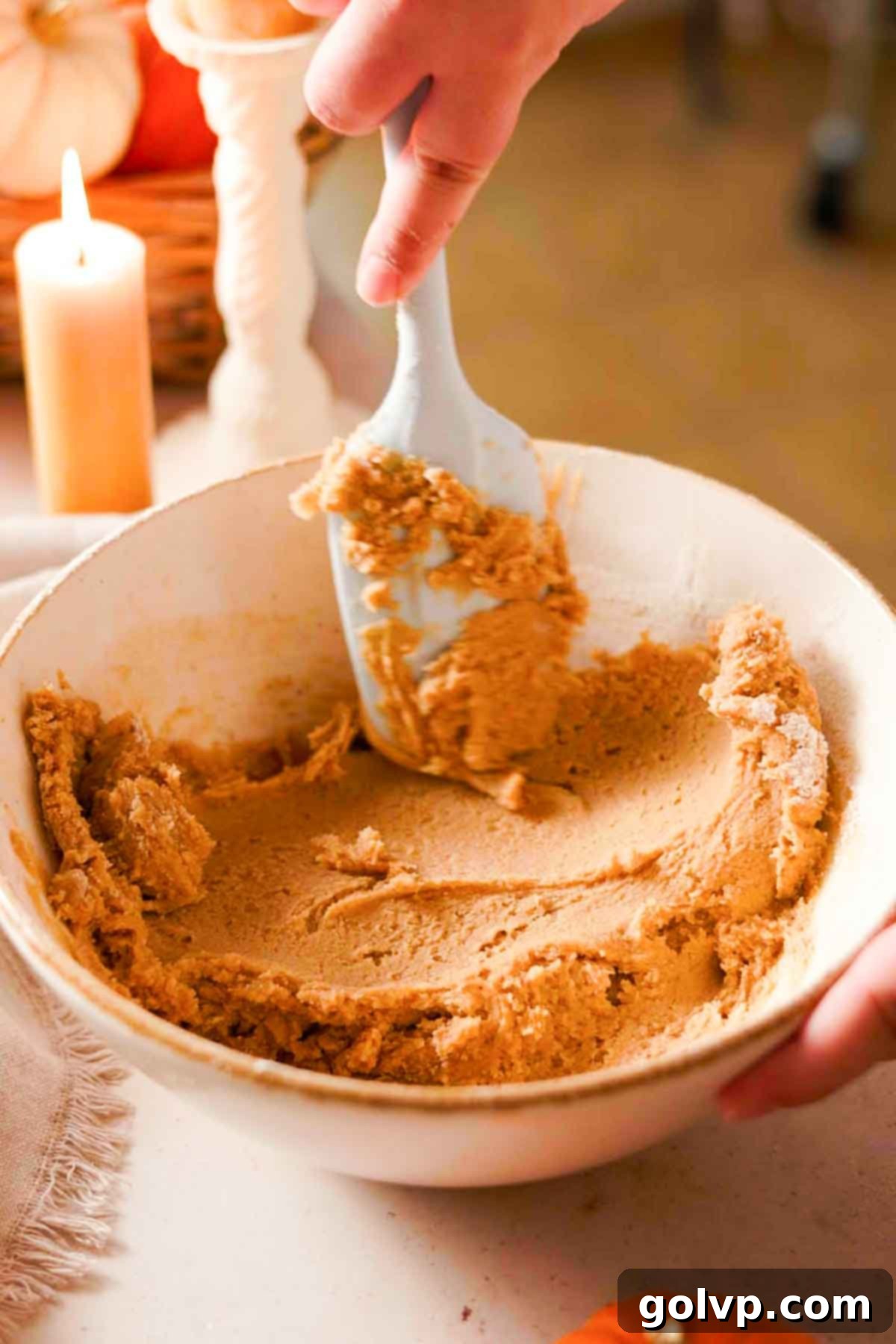 Decadent Pumpkin Cheesecake Cookies 6 smoothing down the cookie dough in a large bowl with a rubber spatula
