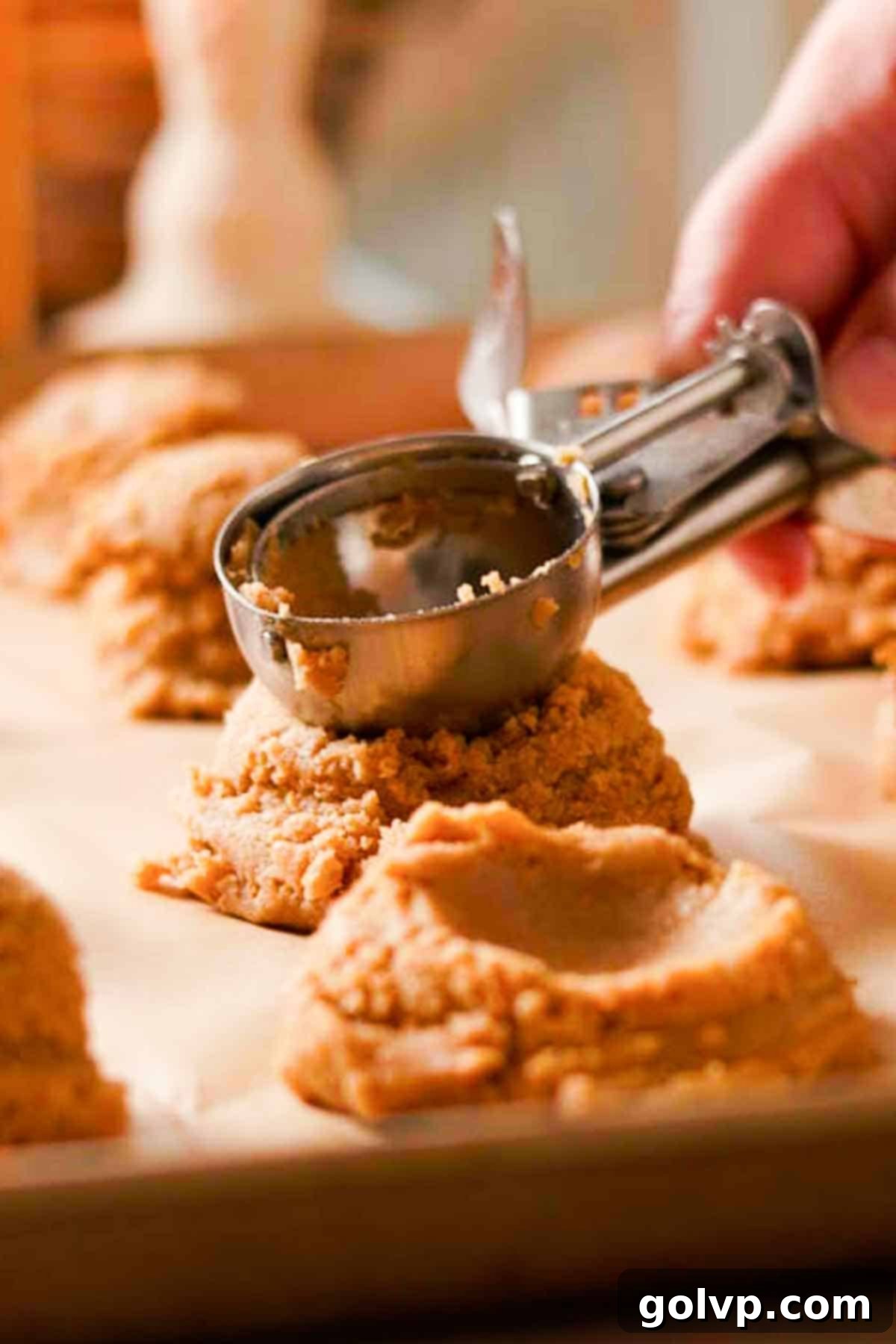 Decadent Pumpkin Cheesecake Cookies 8 scooping and pressing down the tops of cookie dough balls with a cookie scoop