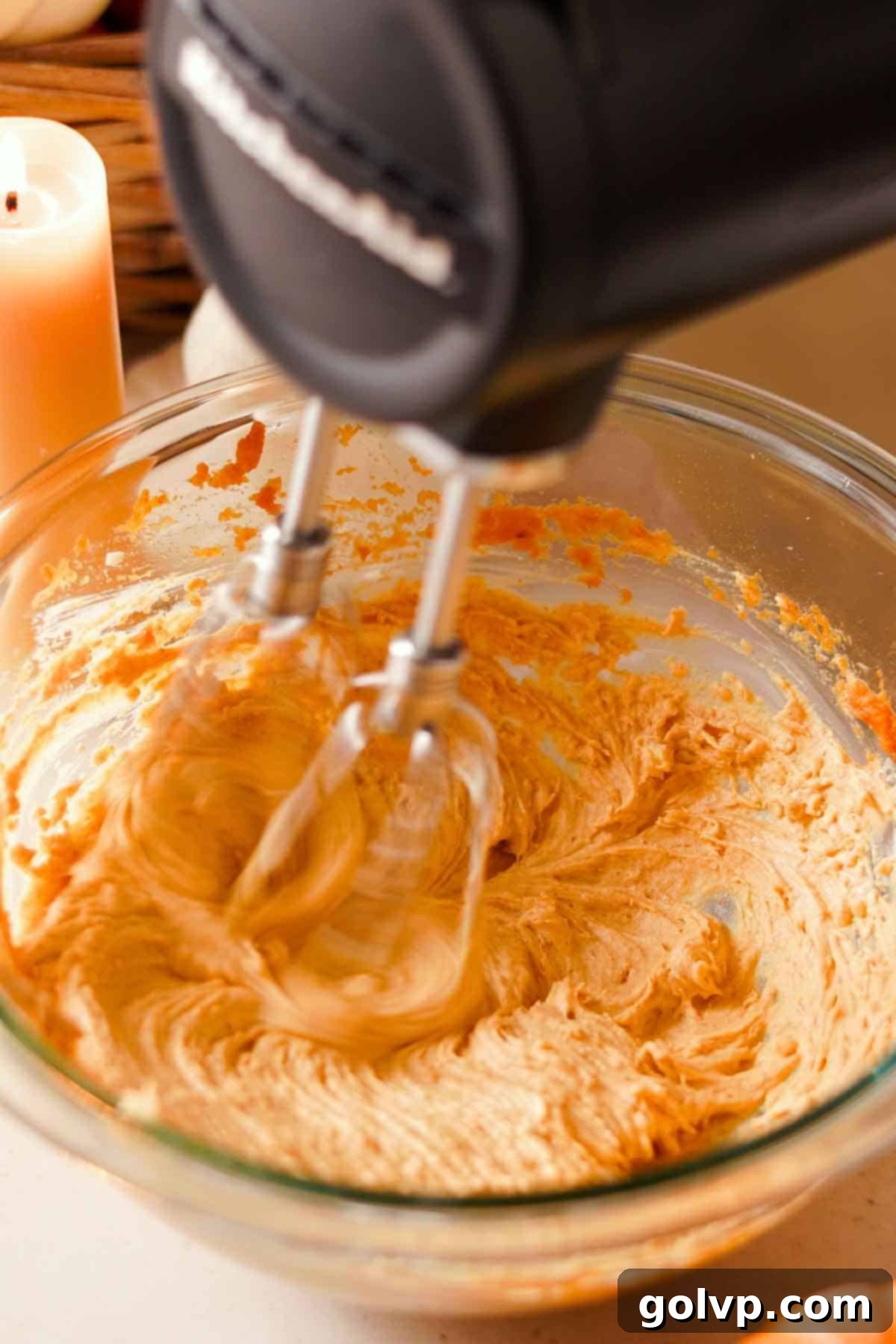 Decadent Pumpkin Cheesecake Cookies 9 beating the cream cheese cookie filling in a glass bowl with a black electric mixer