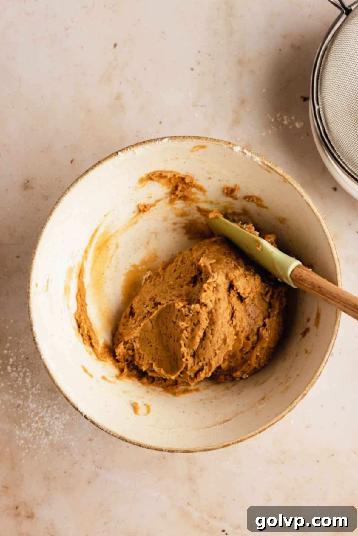 Autumn Pumpkin Biscotti 5 A spatula mixing dry ingredients into the wet mixture, forming a cohesive biscotti dough in a large bowl.