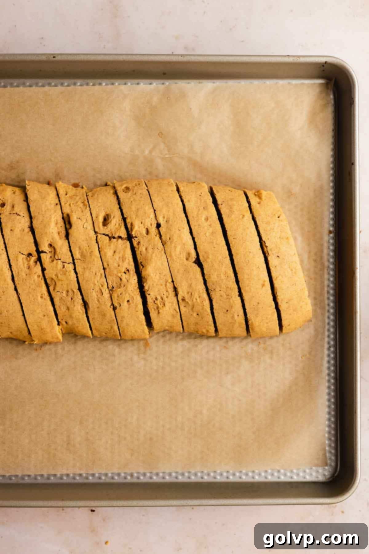 Autumn Pumpkin Biscotti 8 A serrated knife cutting the partially cooled biscotti loaf into uniform slices on a cutting board, creating the iconic biscotti shape.