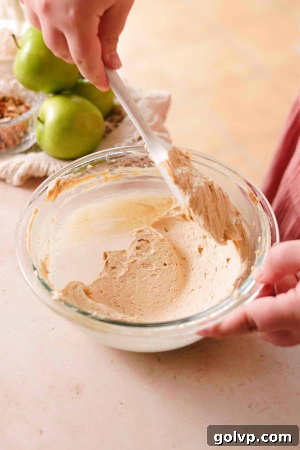 The smooth, creamy, and pale texture of whipped butter and brown sugar in a glass bowl, indicating proper creaming.