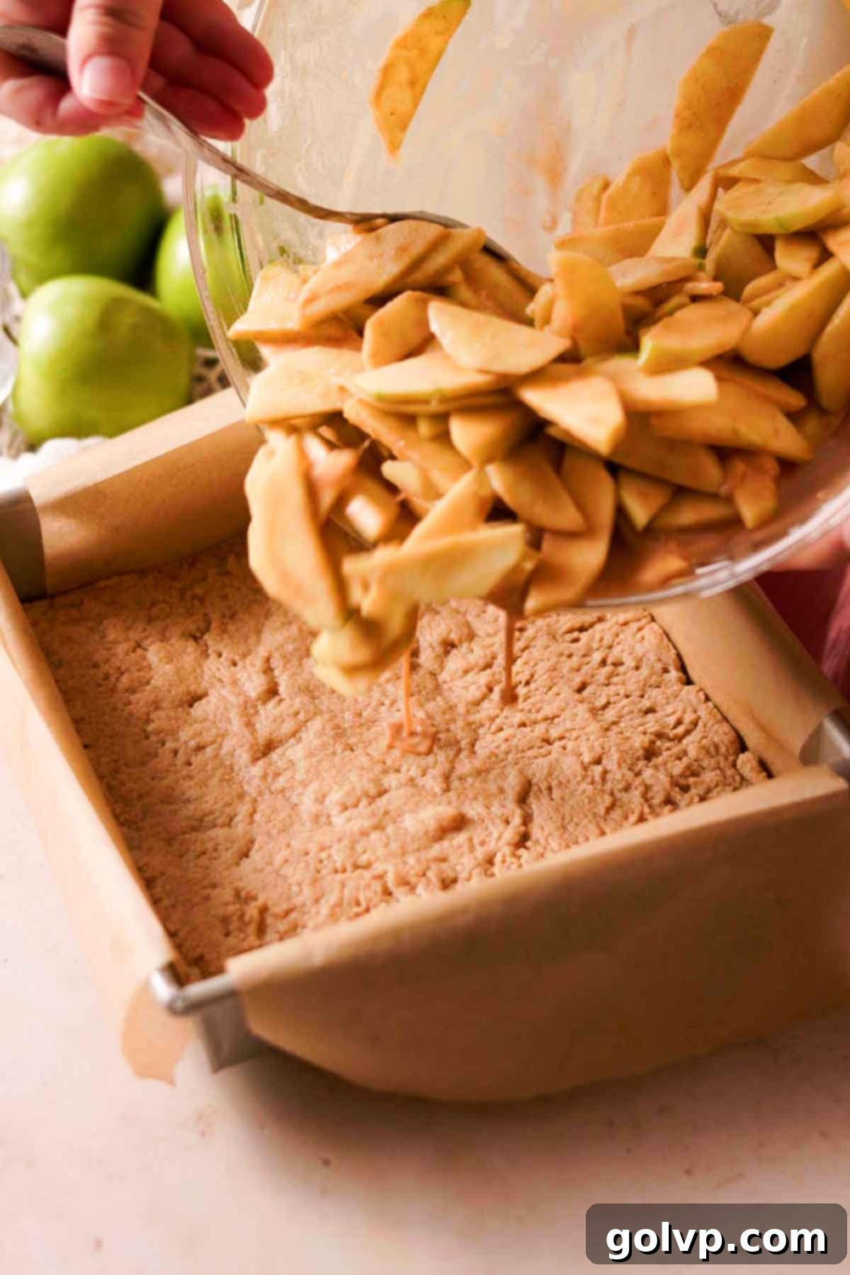 Topping the briefly baked shortbread crust with a generous layer of fresh caramel apple filling.