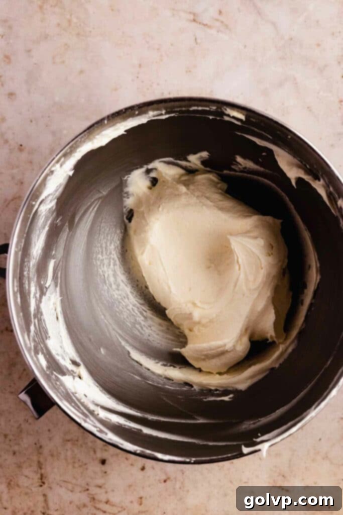 Smooth and creamy cream cheese frosting in a mixing bowl, ready for piping.