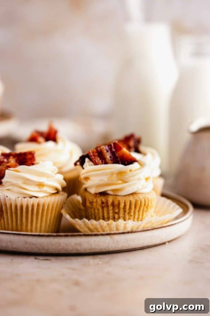 A perfectly baked maple bacon cupcake, with its liner pulled down, showcasing the moist cupcake base before frosting and decoration.