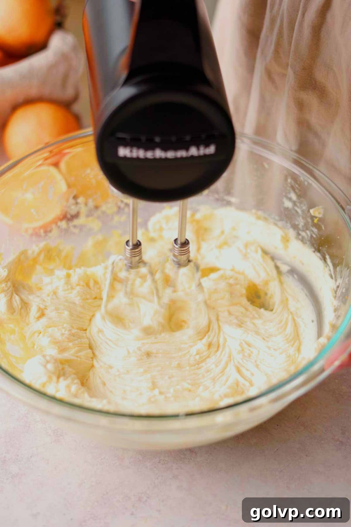 beating cream cheese and orange sugar with an electric handheld mixer