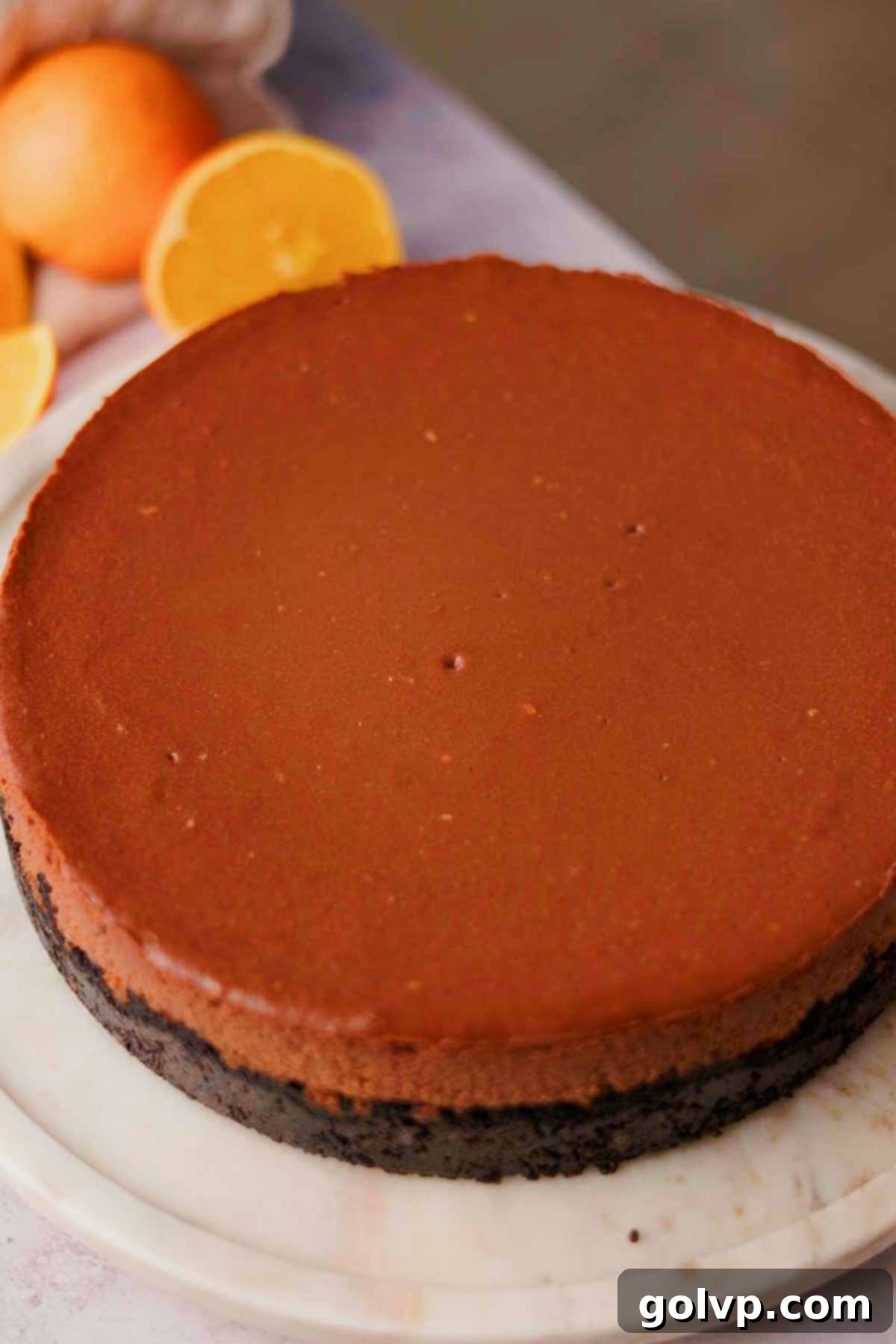 cooled chocolate orange cheesecake ready to be decorated on a cake plate