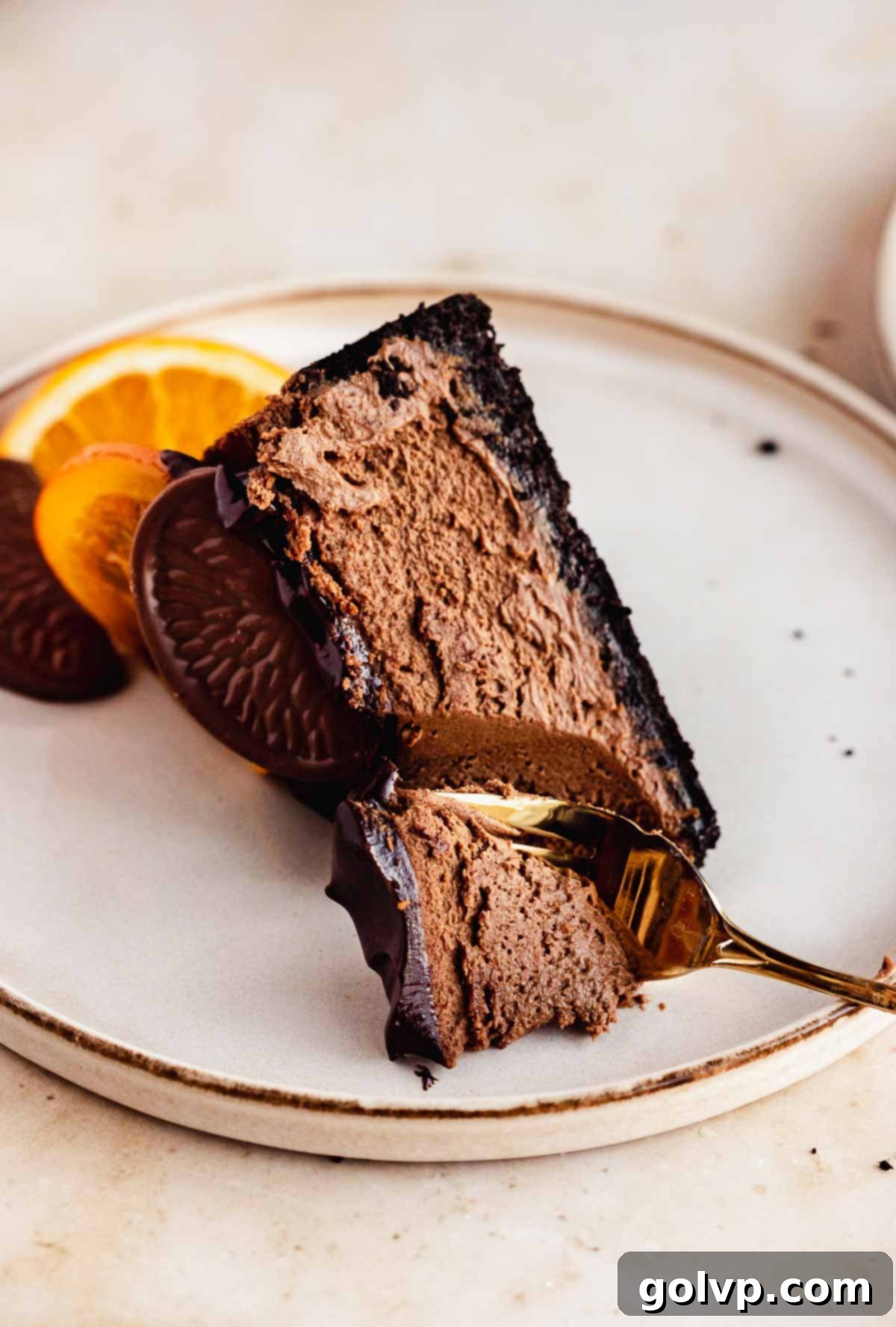 slice of chocolate cheesecake on a plate with a fork in it to show creamy texture