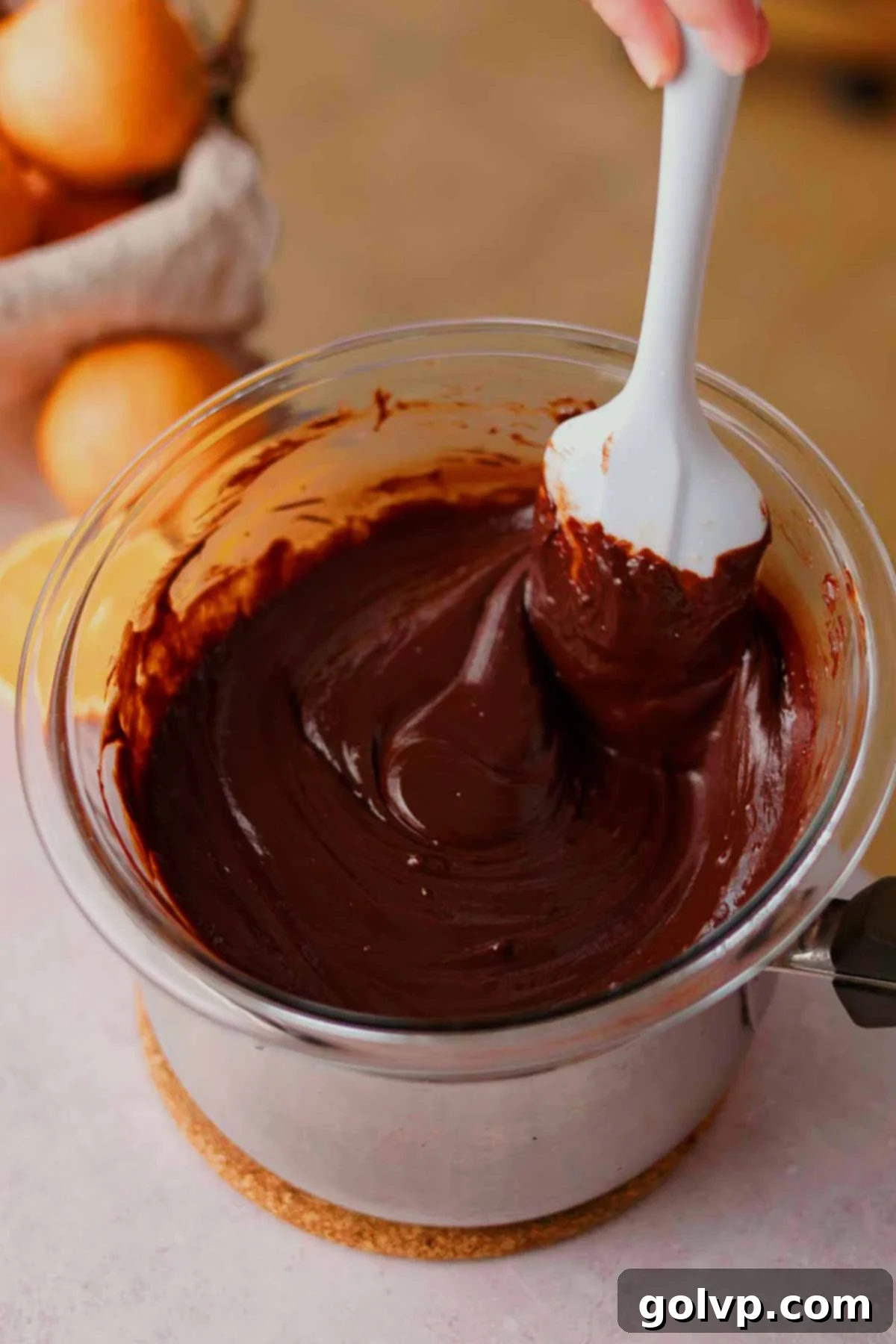 melting chocolate on top of a double boiler with a rubber spatula