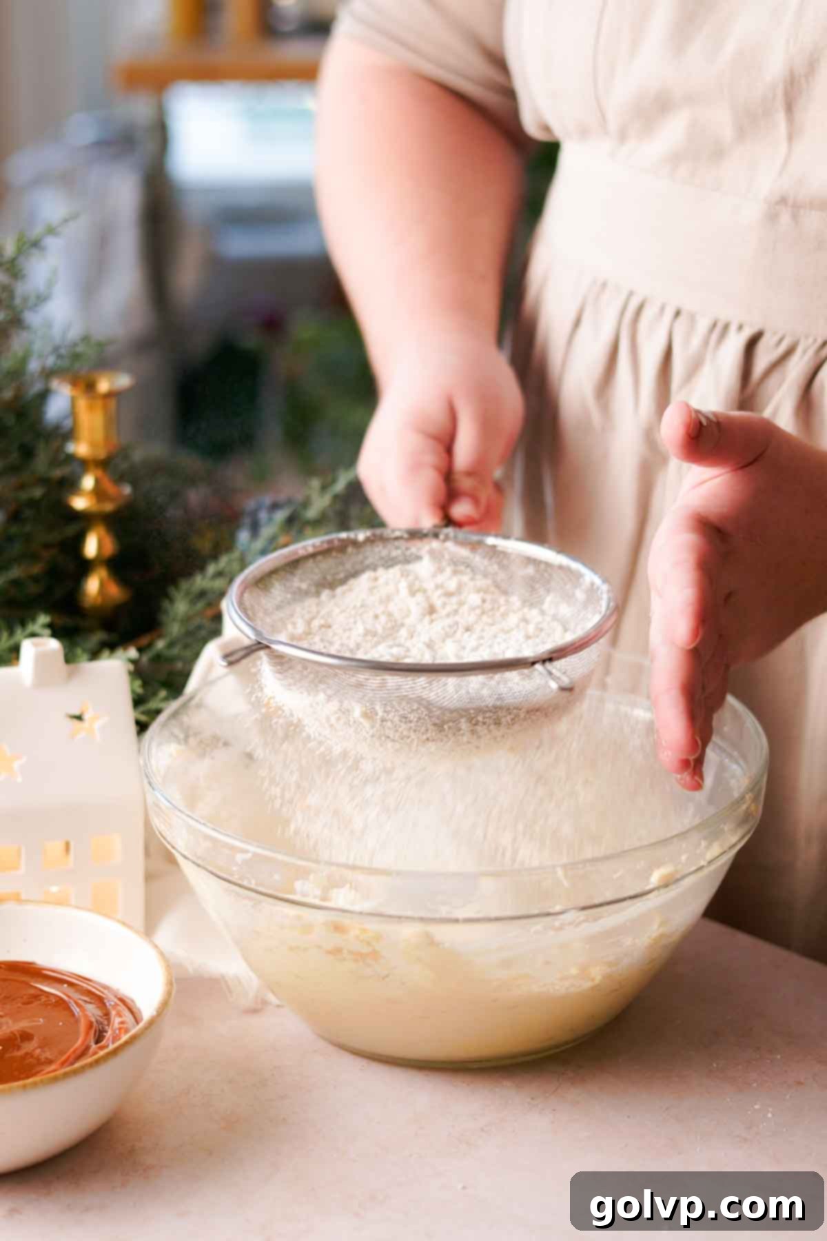sifting dry ingredients into bowl of creamed wet ingredients