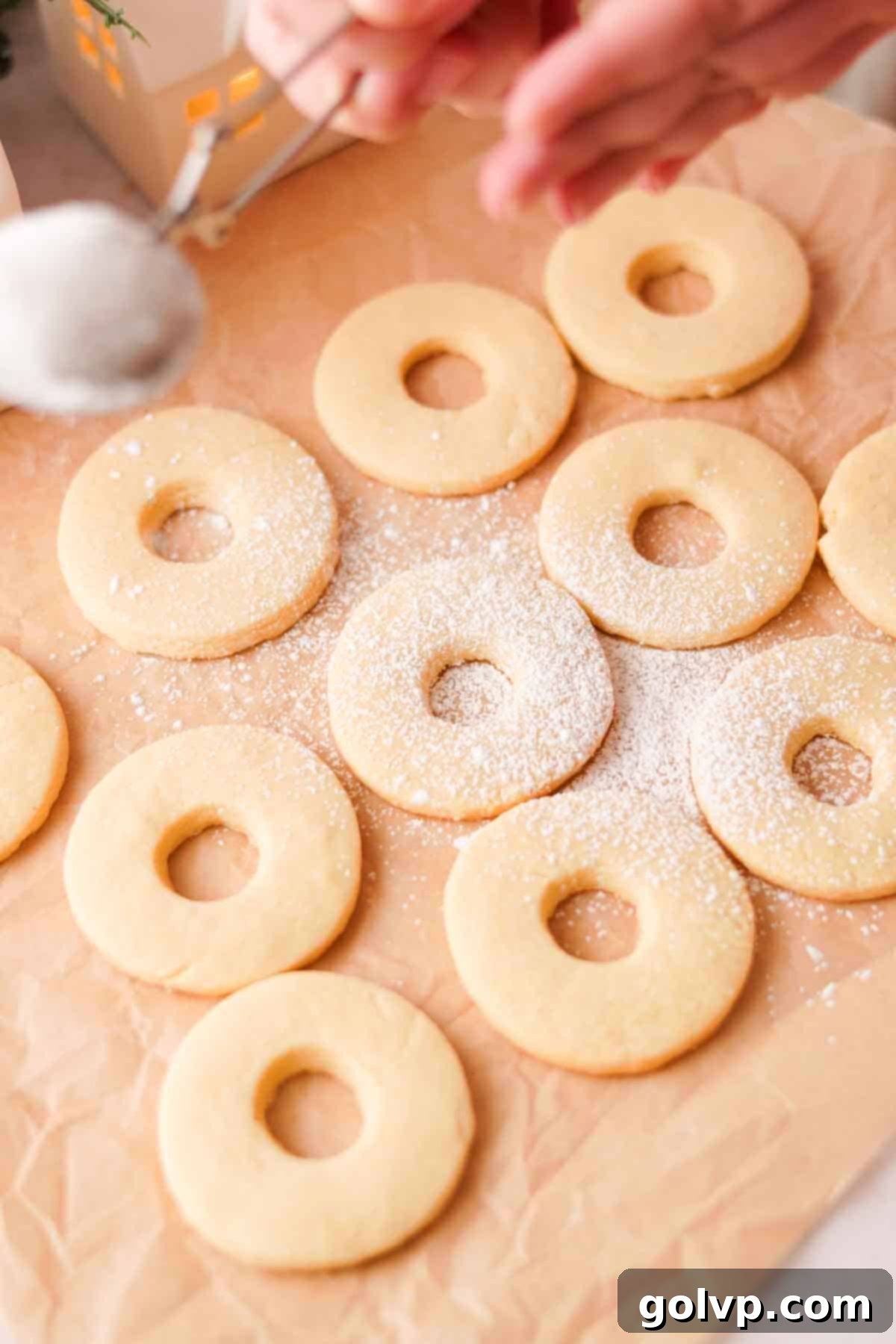 dusting cookies with holes cut out with powdered sugar