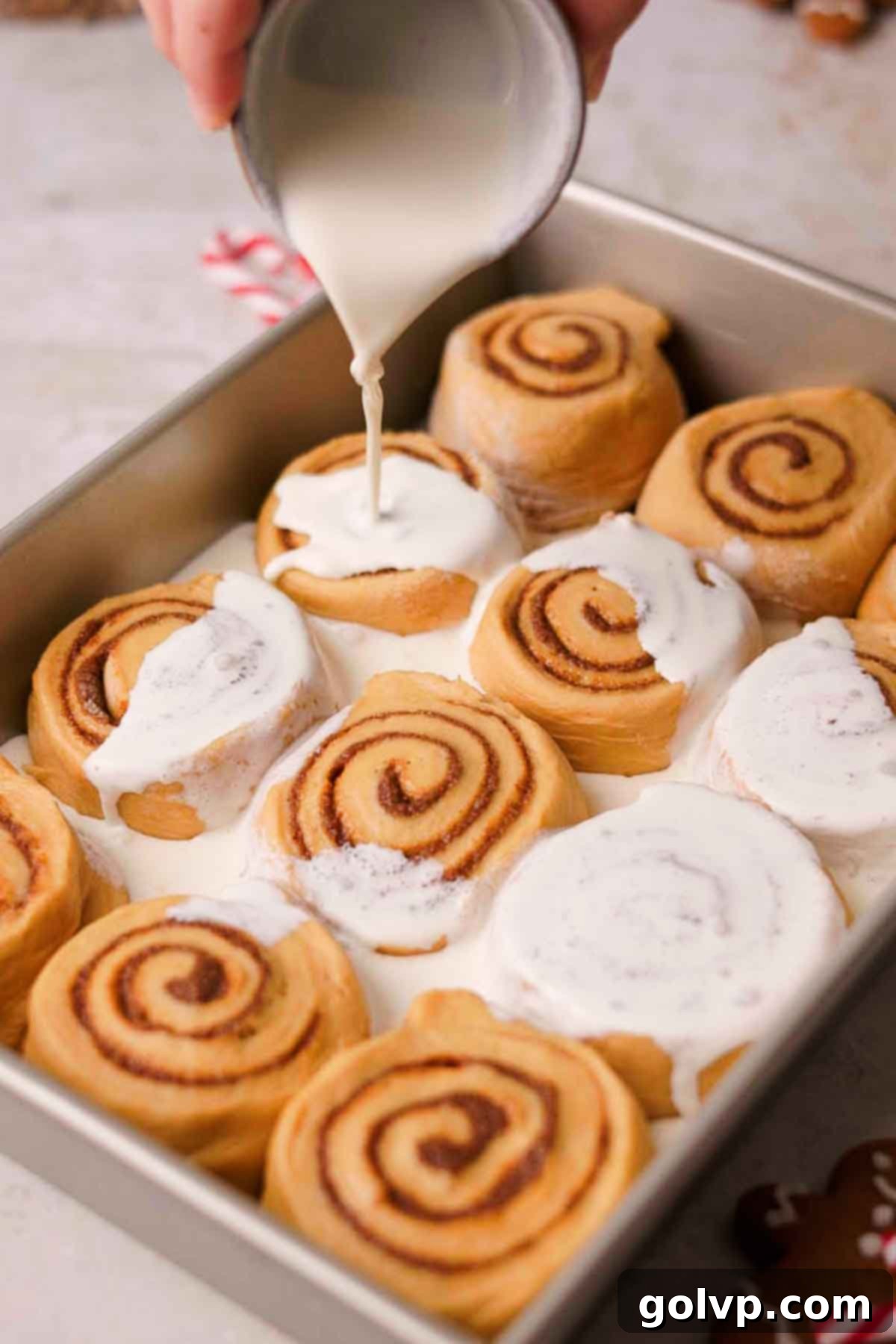 pouring heavy cream on top of cinnamon rolls before baking