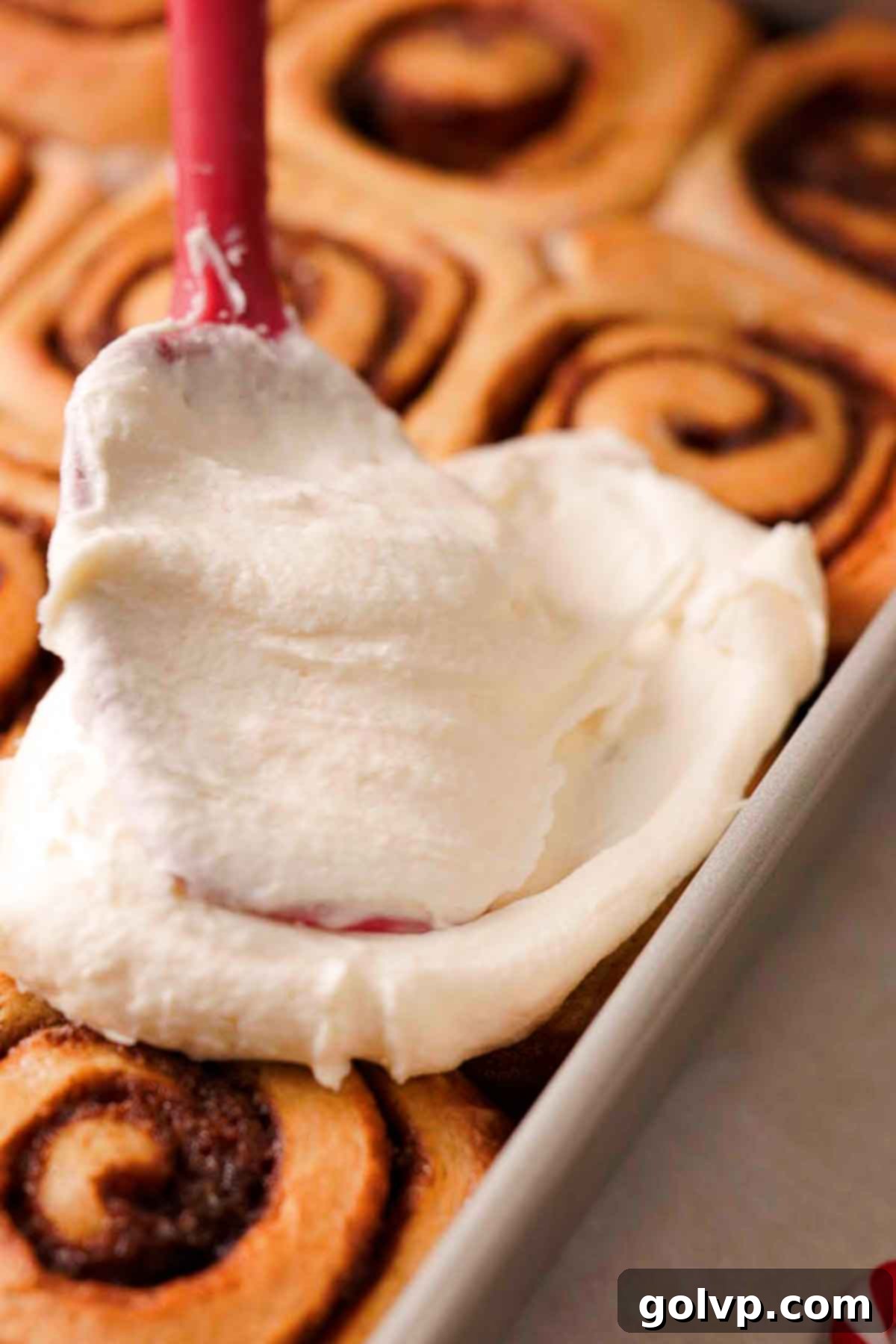 frosting gingerbread cinnamon rolls with white cream cheese frosting