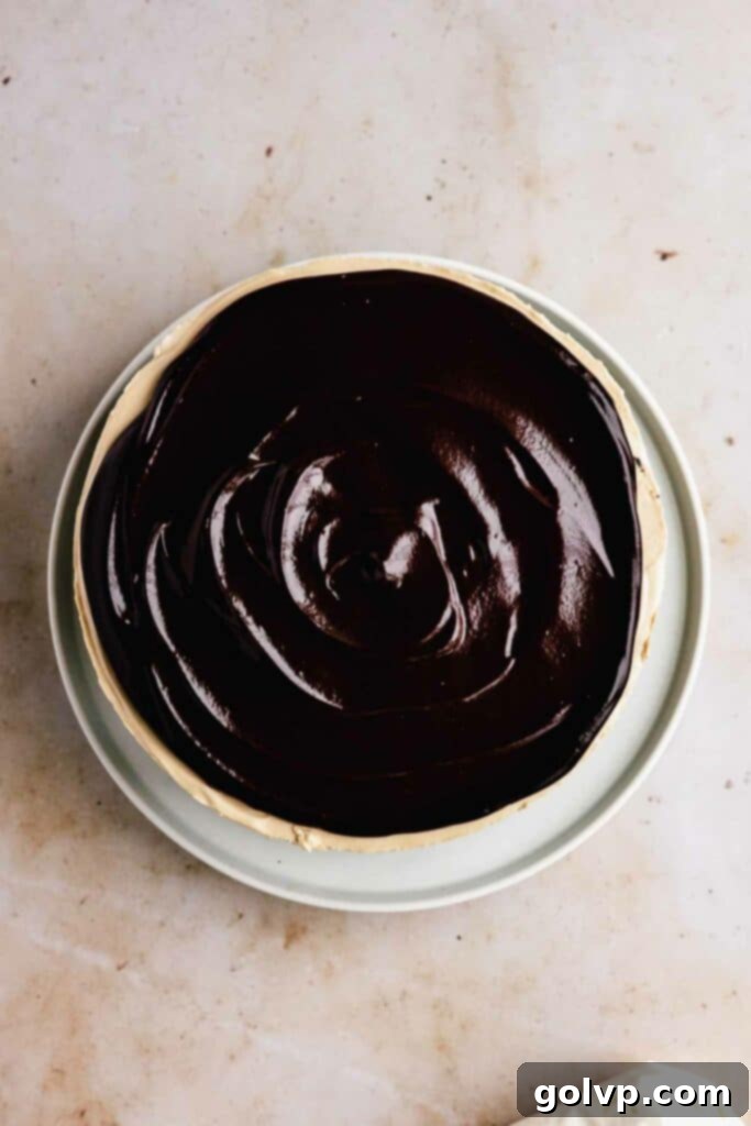 Topping a chilled Baileys cheesecake with smooth chocolate ganache