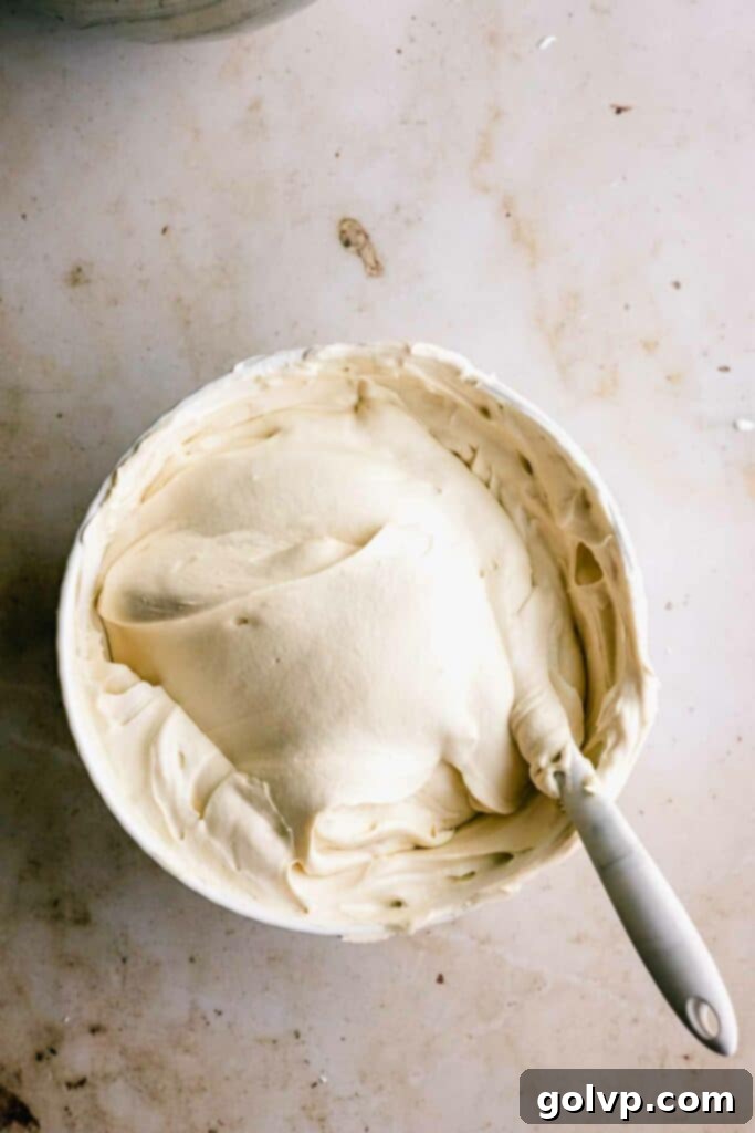 Gently folding whipped cream into the cheesecake filling