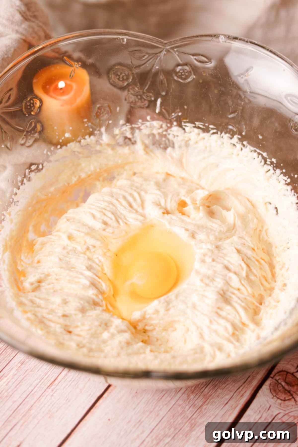 Adding eggs one at a time to the creamed butter and sugar mixture, beating well after each addition to ensure emulsification.