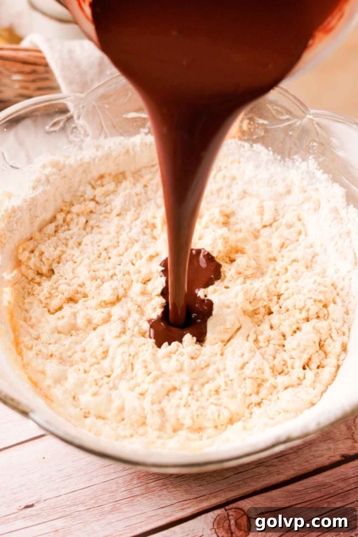 Pouring the cooled bloomed cocoa powder into cake batter.