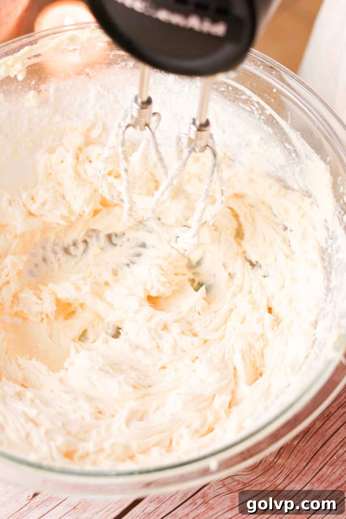 Beating softened unsalted butter and powdered sugar together with an electric mixer until the mixture is light, fluffy, and creamy.