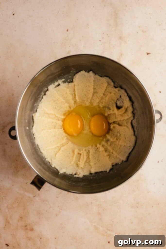 Classic Buttercream Sugar Cookies 6 Adding eggs to beaten butter and sugar mixture for sugar cookie dough