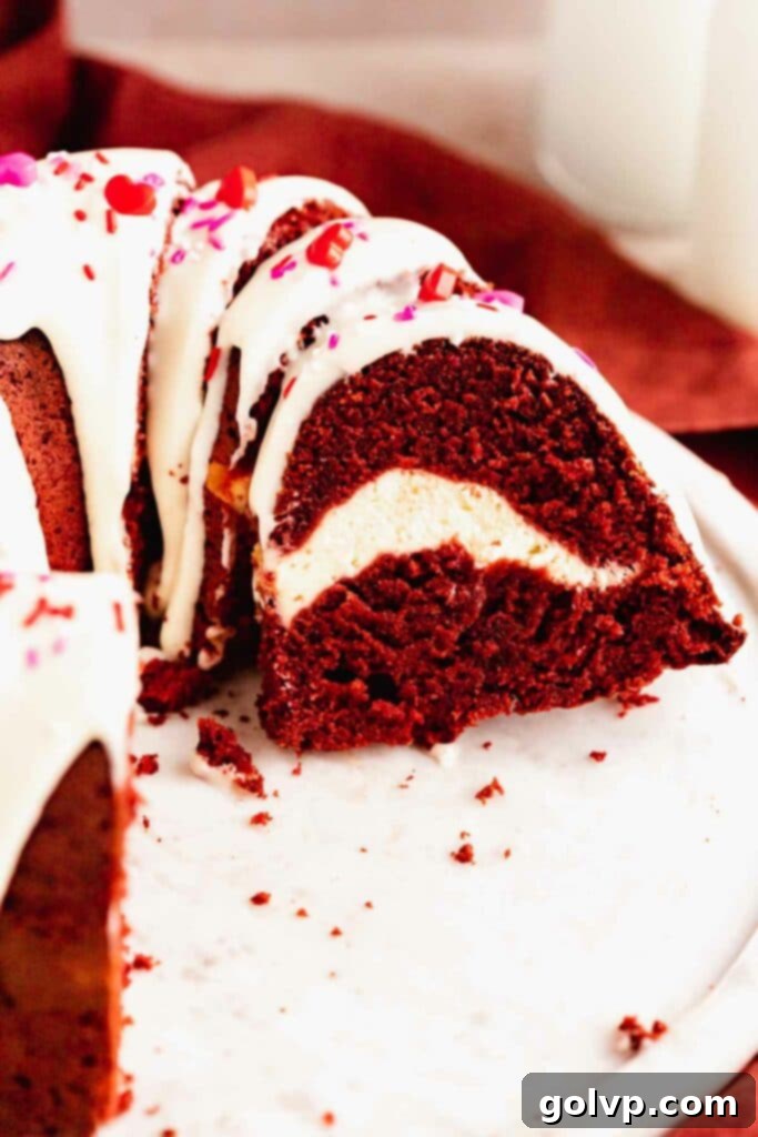 Decadent Red Velvet Bundt with Cream Cheese Swirl 2 Closeup of red velvet bundt cake with cream cheese swirl and glaze, featuring a vibrant red interior and creamy white swirl
