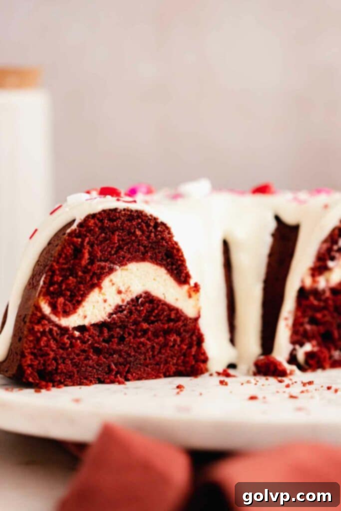 Decadent Red Velvet Bundt with Cream Cheese Swirl 5 Closeup shot of the inside of a baked red velvet bundt cake, highlighting the beautiful cream cheese swirl with a creamy white contrast against the vibrant red cake.