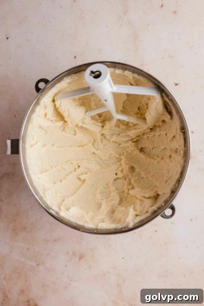 Image showing the process of beating butter, sugar, and oil together in a mixer for the bundt cake batter.