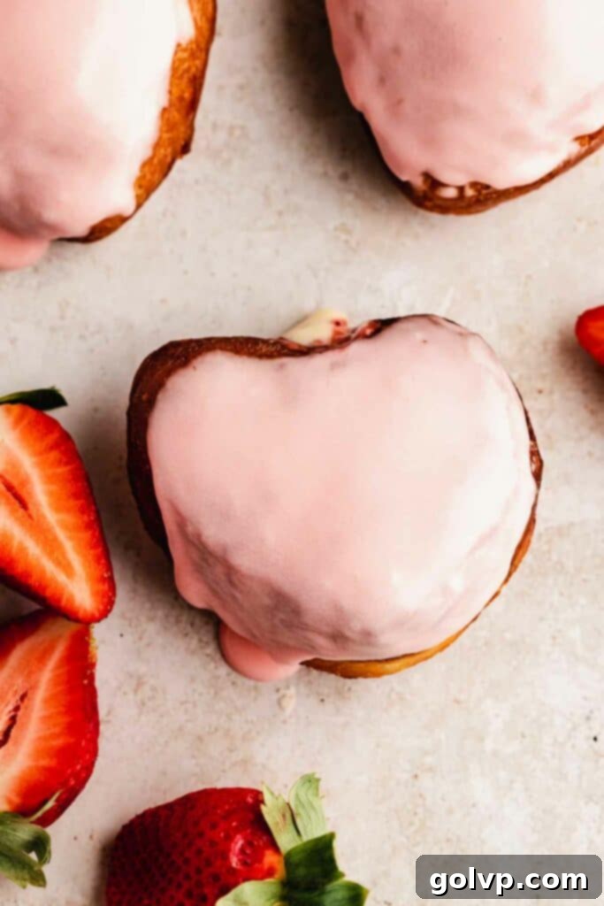 heart shaped donut covered with glaze and fresh strawberries