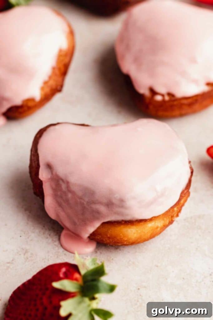 heart shaped strawberry donuts with glaze dripping off