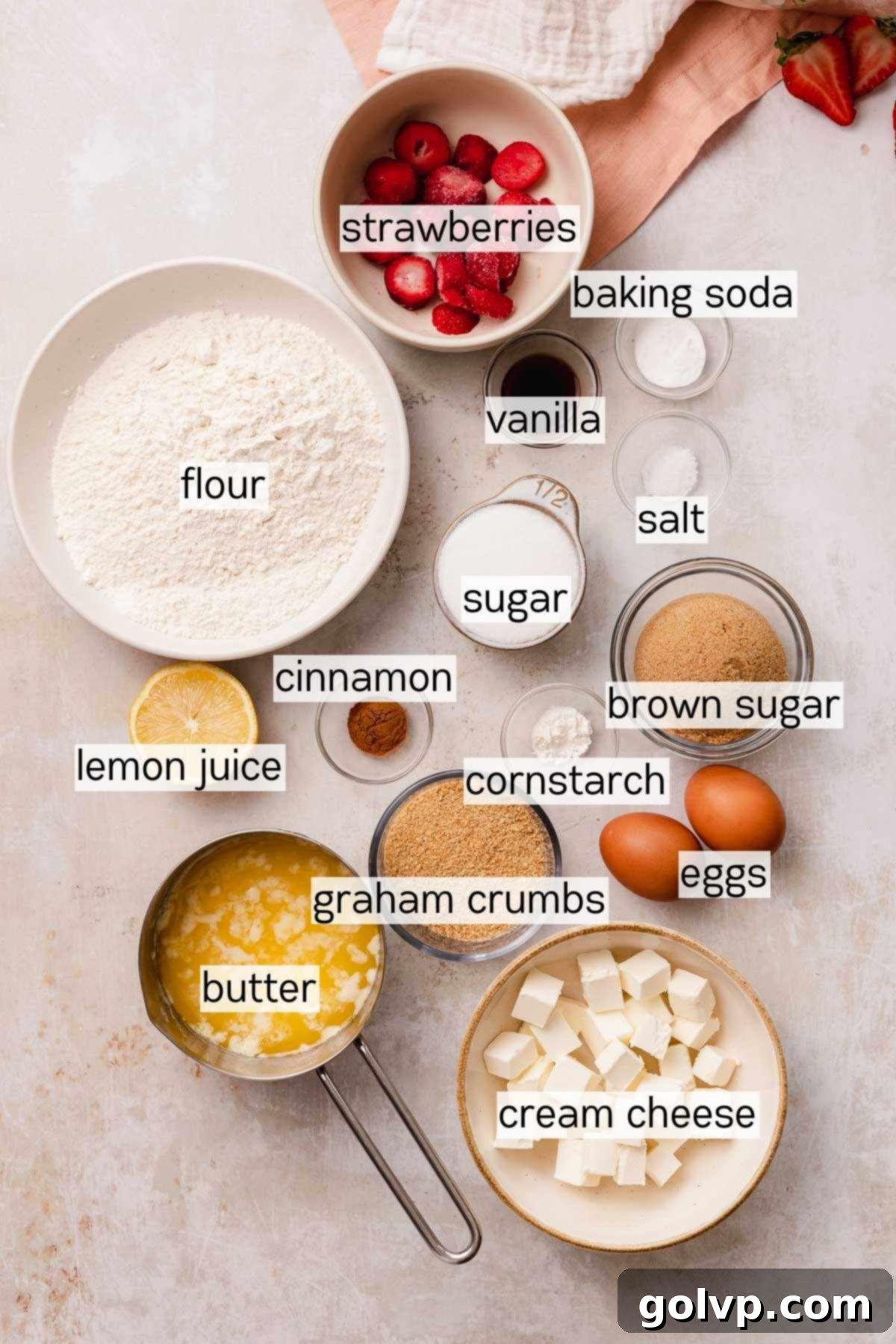 Decadent Strawberry Cheesecake Cookies 4 Various ingredients for strawberry cheesecake cookies laid out in bowls, including cream cheese, strawberries, and graham crackers
