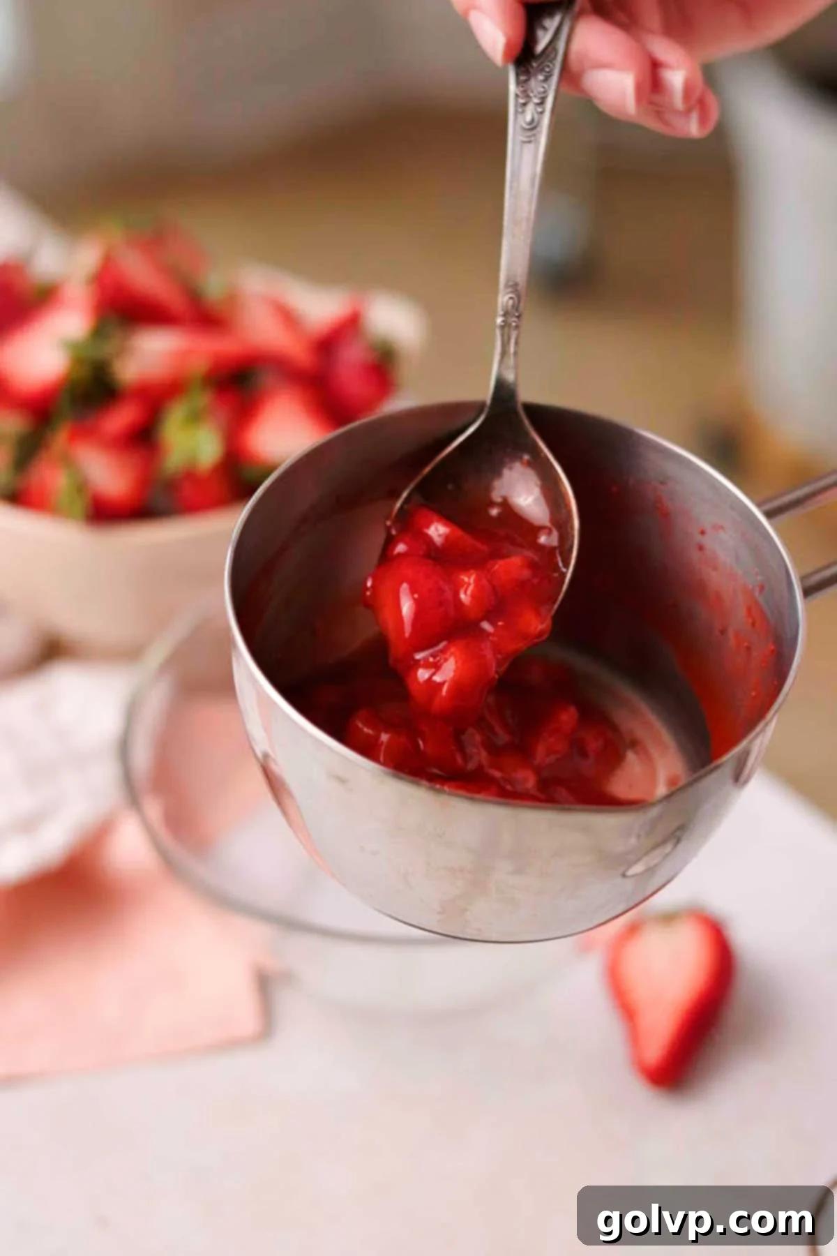 Decadent Strawberry Cheesecake Cookies 6 Thick, cooked strawberry sauce dripping from a spoon, showing its rich texture