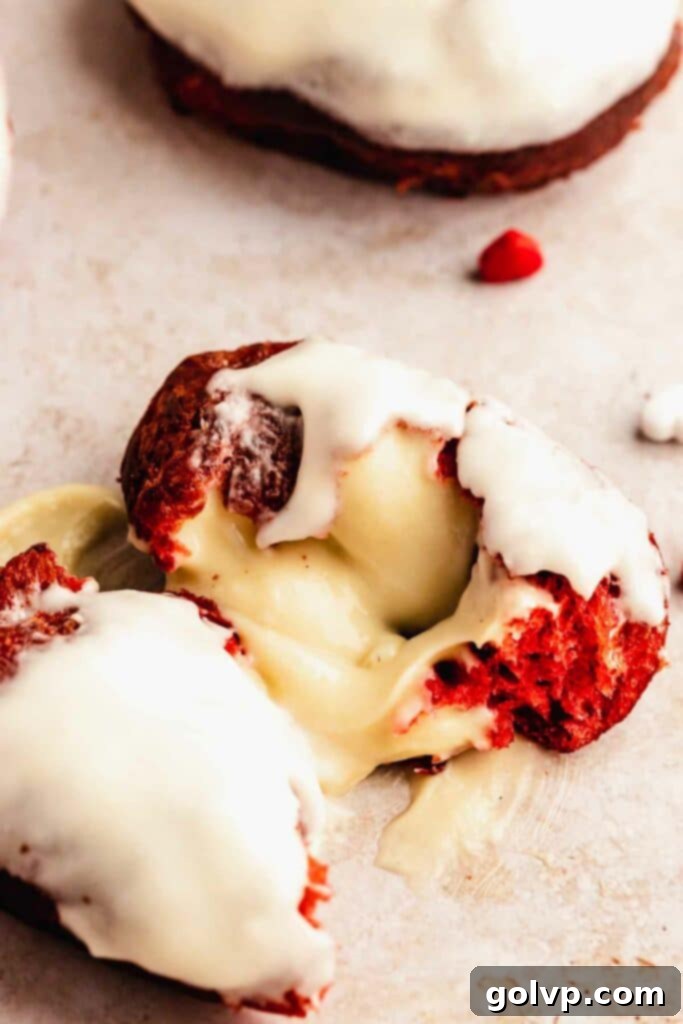Filled red velvet donut with cream cheese glaze and a sprinkle of cocoa