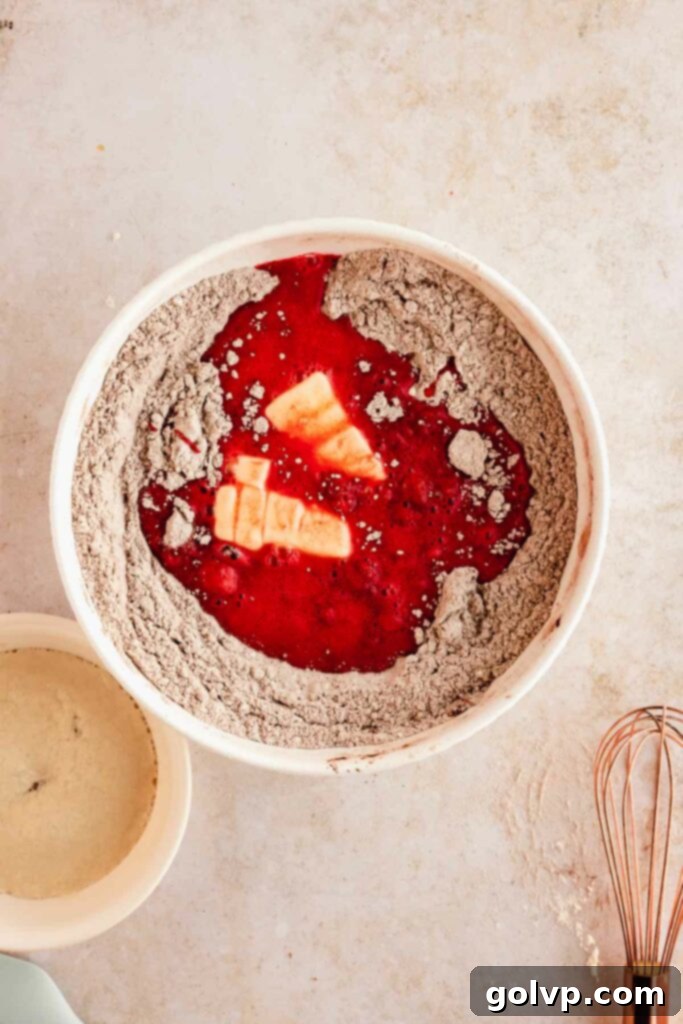 mixing red velvet fried donut dough in a bowl