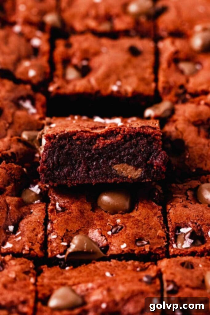 A side view of fudgy red velvet brownies, highlighting their thickness and the distribution of chocolate chips.