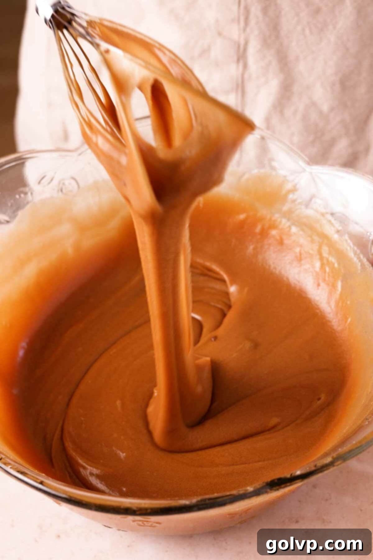 Close-up of the red velvet brownie batter showing the eggs, sugar, and butter mixed to a light, airy consistency.