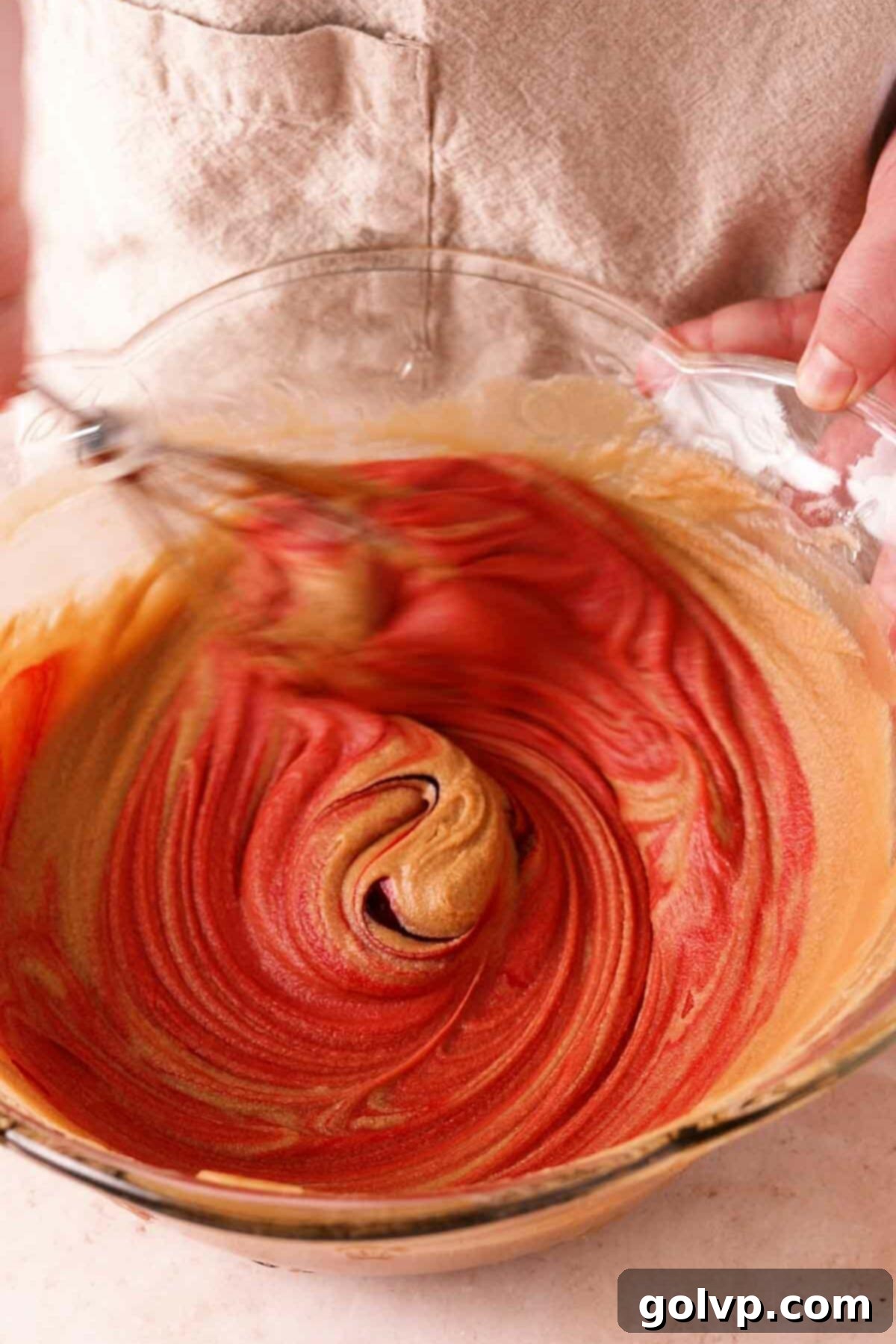 Red velvet batter with the vibrant red food coloring fully incorporated, ready for dry ingredients.